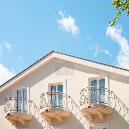 Téléchargez les photos : Le dernier étage d'un immeuble avec un balcon contre le ciel bleu. Nuages blancs clairs. - en image libre de droit