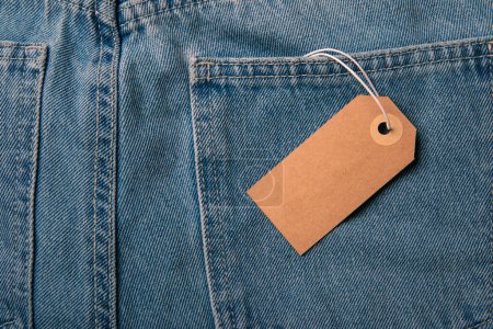 Téléchargez les photos : Gros plan jeans avec étiquette de prix en carton vierge pour votre texte - en image libre de droit