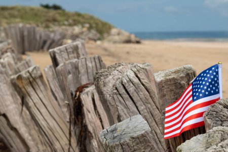 Utah Beach WWII mit Flagge der USA selektiver Fokus auf Flagge. Sandstrand und Zaunpfähle. In der Normandie erinnert Frankreich an den Veteranentag. Hochwertiges Foto