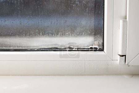 Téléchargez les photos : Ice forming on the inside of a window. incorrect window installation, window adjustment, heating problems - en image libre de droit