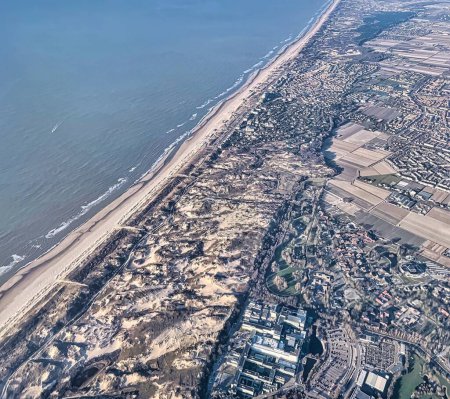 Photo for In air, Netherlands - March 07 2022: an aerial view of the dutch coast with beaches, dunes and nature and the wide open north sea - Royalty Free Image