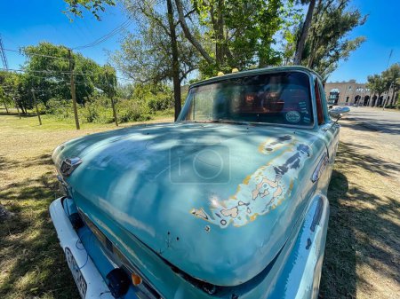 Foto de Colonia del sacramento, uruguay - 2 de noviembre de 2022: una furgoneta vintage de color azul oxidado f-100 1960s recoger camión estacionado a lo largo de la carretera - Imagen libre de derechos