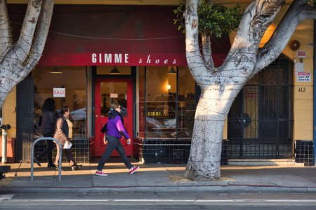 Foto de San Francisco, Estados Unidos - 14 de febrero de 2020: personas caminando por la acera pasando por una zapatería en la parte baja de la calle - Imagen libre de derechos