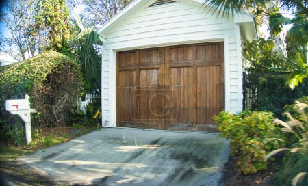 Foto de Charleston, Estados Unidos - 5 de noviembre de 2022: una puerta de garaje de madera en una elegante casa con camino de entrada en un barrio suburbano - Imagen libre de derechos
