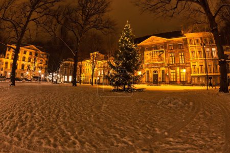 Foto de La Haya, Países Bajos - 20 de diciembre de 2009: sepia acentúa la belleza. Un gran árbol de Navidad en la plaza Lange Voorhout con casas iluminadas históricas holandesas por la noche - Imagen libre de derechos