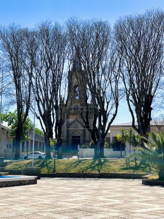 Téléchargez les photos : Nueva helvecia, uruguay - 1er novembre 2022 : parroquia de la santisima trinidad clocher et arbres devant elle - en image libre de droit