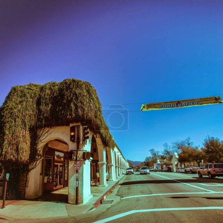 Foto de Ojai, Estados Unidos - 25 de febrero de 2013: Una tienda en la calle principal de la ciudad ha sido cubierta por hiedra, plantas silvestres y colinas en el fondo
. - Imagen libre de derechos
