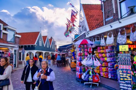 Photo for Volendam, netherlands - 08 October 2022: people walking on harbor front of dutch village with souvenir shops and terraces - Royalty Free Image