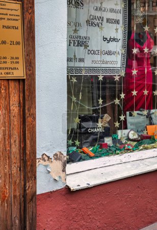Téléchargez les photos : Moscou, Russie - Septembre 11 2010 : l'ancien magasin avec de la rouille et de la mauvaise peinture où dans la vitrine des vêtements occidentaux coûteux est solled - en image libre de droit