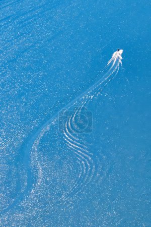 Téléchargez les photos : Talloires, France - 08 septembre 2020 : une vue aérienne d'un hors-bord qui roule vite et qui a des traces de vagues derrière lui - en image libre de droit