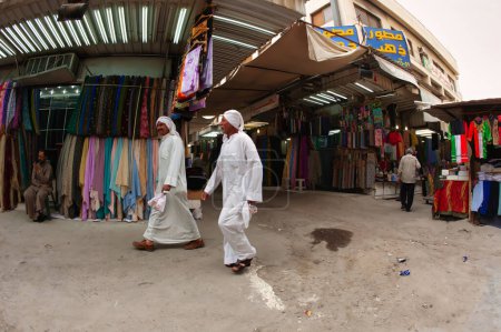 Téléchargez les photos : Koweït, Koweït - 24 février 2010 : deux hommes vêtus de foulards dégel et foulards marchent sur le marché extérieur dans le centre de la ville - en image libre de droit