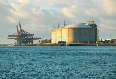 Rotterdam, Niederlande - 11. November 2021: Linien mit riesigen, halbautomatischen Kränen zum Abladen von Containern von Schiffen und Öltanks im Hafen