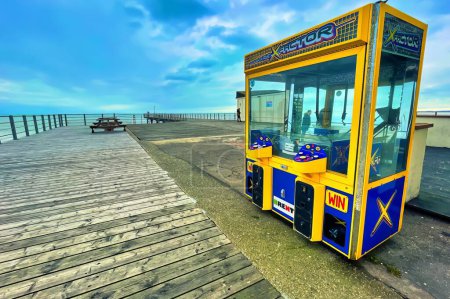 Photo for Bognor regis, united kingdom - March 04 2022: an arcade game grab machine has been placed on the wooden pier of an english seaside resort - Royalty Free Image