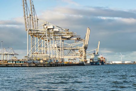 Rotterdam, Niederlande - 22. November 2021: Linien mit riesigen, halbautomatischen Kränen zum Abladen von Containern von Schiffen im Hafen