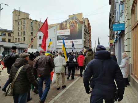 Foto de Letonia, Riga, 16.03.2023. Una memorable procesión de legionarios letones "Waffen-SS" en el centro de Riga bajo la protección de las fuerzas especiales de la policía. Los ucranianos que recibieron asilo en Letonia participaron en la marcha. - Imagen libre de derechos