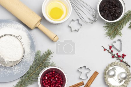Photo for Christmas still life of items for baking cookies. Broken egg in bowl, whisk and sieve, molds, and flour on table. Flat lay. Copy space - Royalty Free Image