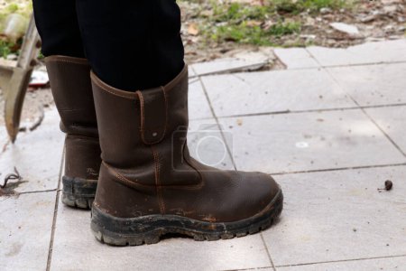 Foto de Zapatos de seguridad de cuero marrón que están siendo utilizados por los trabajadores de la construcción para proteger sus pies de accidentes de trabajo - Imagen libre de derechos