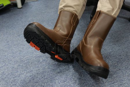 Foto de Los trabajadores usan botas marrones, estos zapatos de seguridad están hechos de cuero, estos zapatos se utilizan para proteger los pies de lesiones mientras trabajan. - Imagen libre de derechos