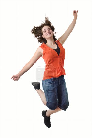 Une femme brune joyeuse saute avec ses cheveux volant dans les airs sur un fond blanc, rayonnant de bonheur et d'énergie.