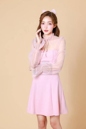 Foto de Mujer asiática linda joven en un vestido elegante rosa, maquillaje de estilo coreano, piel hidratada, lisa, perfecta sobre un fondo beige. Tratamiento facial, Cosmetología, cirugía plástica. - Imagen libre de derechos