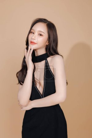 Photo for High fashion of perfect slim body beautiful face young elegant woman in black dress on isolated beige background. Portrait of female model in studio. plastic surgery and aesthetic cosmetology. - Royalty Free Image