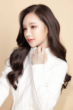 Photo for Young Asian beauty woman long back hair in sweater with Koreans makeup style on face and perfect clean skin on isolated beige background. Facial treatment, Cosmetology, plastic surgery. - Royalty Free Image