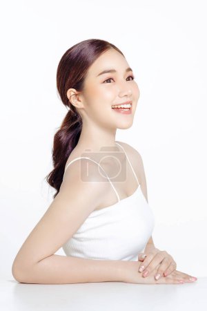 Photo for Asian woman with a beautiful face gathered in a brown ponytail and clean fresh smooth skin. Cute female model with natural makeup and sparkling eyes on white isolated background. - Royalty Free Image