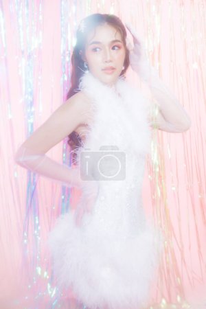 Photo for Young Asian woman with a beautiful face wear glamour dress poses surround by a rainbow curtain party.  people, holidays, emotion and glamour concept. - Royalty Free Image