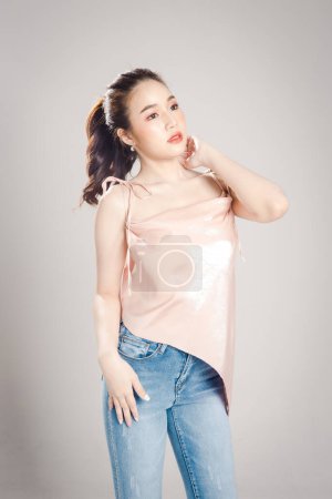 Beautiful young Asian woman is happy posing look away isolated on grey banner background. 