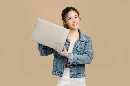 Photo for Smile beautiful Asian woman holding a blank white billboard on Isolated beige background.. look at camera, copy space. - Royalty Free Image