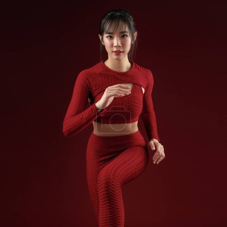 Photo for Energetic Asian fit slim good shape body building athletic woman in red sportwear workout indoor studio. Young strong female model aerobic running, skin care, wellness, Health insurance. - Royalty Free Image