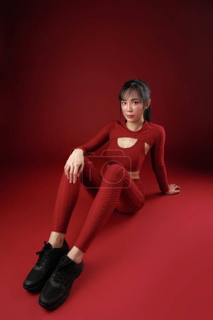 Photo for Energetic Asian fit slim good shape body building athletic woman in red sportwear workout indoor studio. Young strong female model aerobic training skin care, wellness, Health insurance. - Royalty Free Image