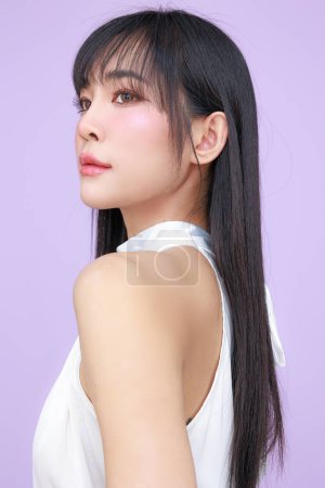 Photo for Beautiful young Asian woman model long hair with natural makeup on face clean skin on isolated violet background. Cute girl portrait, Facial treatment, Body care, Beauty and Spa. - Royalty Free Image