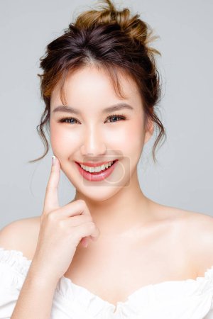 Photo for Asian woman with a beautiful face and Perfect clean fresh skin. Portrait of female model with natural makeup and sparkling eyes on Grey isolated background. Cosmetology, Body care, plastic surgery. - Royalty Free Image