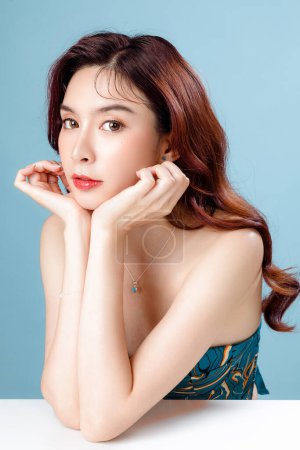Photo for Asian woman with a beautiful face and Perfect clean fresh skin. Cute female model with natural makeup and sparkling eyes on blue isolated background. Facial treatment, Cosmetology, beauty Concept. - Royalty Free Image