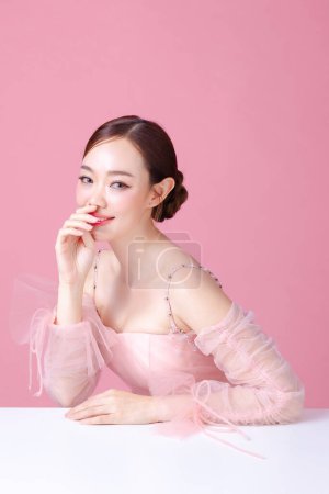 Photo for Beautiful young Asian woman model bun hair with natural makeup on face clean fresh skin on isolated pink background. Cute girl portrait, Facial treatment, Valentine concept. - Royalty Free Image