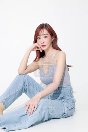 Photo for Young Asian beauty woman sexy model wearing V neck tank top curly long hair with korean makeup style on her face and perfect skin on isolated beige background. Facial treatment, Cosmetology. - Royalty Free Image