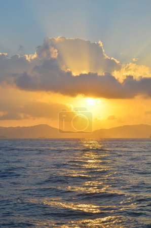 Téléchargez les photos : Les rayons du soleil éclatant à travers les nuages au-dessus de la mer - en image libre de droit