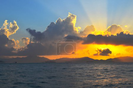 Téléchargez les photos : Les rayons du soleil éclatant à travers les nuages au-dessus de la mer - en image libre de droit