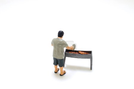 Téléchargez les photos : Une mini figurine de gros garçon avec barbecue - en image libre de droit