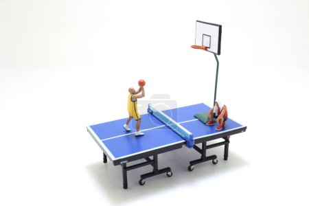 Photo for Fun of figure basketball player on table tennis table - Royalty Free Image