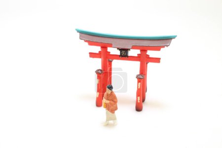 Photo for The Elegance in Motion, Kimono Clad Lady with Torii Figurine - Royalty Free Image