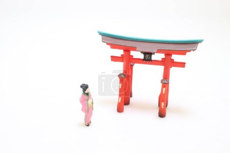 Téléchargez les photos : L'élégance en mouvement, Kimono Clad Lady avec figurine Torii - en image libre de droit