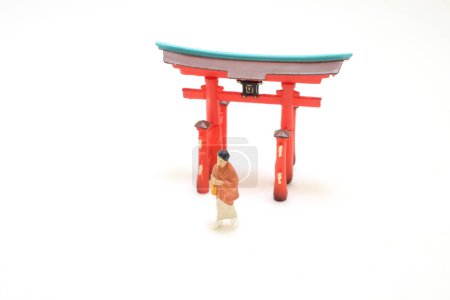 Téléchargez les photos : L'élégance en mouvement, Kimono Clad Lady avec figurine Torii - en image libre de droit