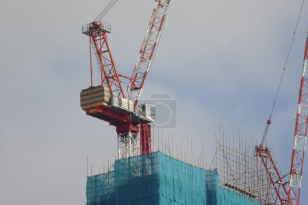 Téléchargez les photos : Grue et chantier de construction contre ciel bleu 30 sept 2023 - en image libre de droit