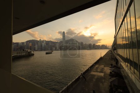Téléchargez les photos : Hong Kong - 08 déc. 2023 : Vue panoramique du paysage urbain moderne sous un ciel nuageux au coucher du soleil - en image libre de droit