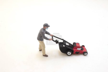 Foto de The gardener repairs the lawnmower. Garden maintenance - Imagen libre de derechos