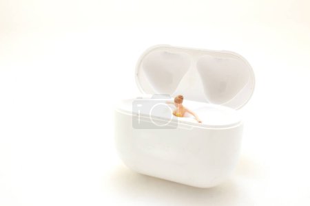 Téléchargez les photos : Personne miniature se relaxant dans un récipient blanc ouvert - en image libre de droit