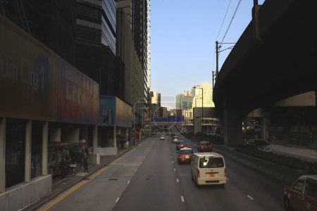 Téléchargez les photos : Paysage urbain avec ciel clair, bâtiments et voitures sur la route. Nov 25 2023 - en image libre de droit