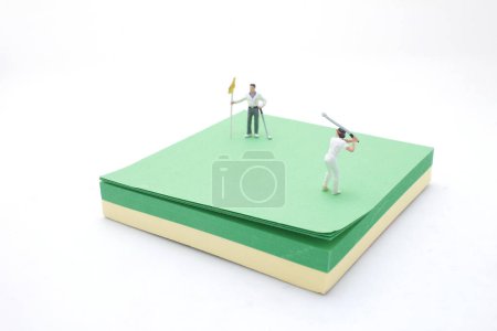 Téléchargez les photos : Une figurine de golfeur sur la balle de golf sur le bloc-notes - en image libre de droit